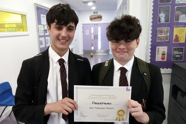 Lewis and Gabriel holding their certificate for best fakeaway dessert